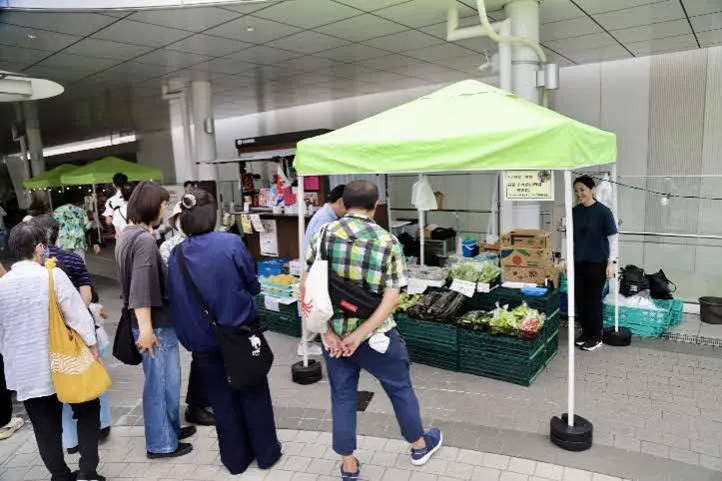 スカイパレットでの出展ブースで野菜を販売し、それを見ている人たち